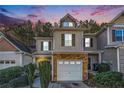 Attractive three-story home with stone accents and a two-car garage at dusk at 228 Ridge Mill Dr, Acworth, GA 30102