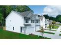 A side view of newly constructed townhomes with gray shudders and green landscaping at 4268 Notting Hill Dr # 27, Atlanta, GA 30331