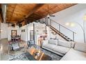 Modern living room with exposed wood ceilings, stainless staircase, and open floor plan at 170 Boulevard Se # H412, Atlanta, GA 30312