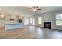 Open-concept living space with fireplace, kitchen, and hardwood-style floors at 123 Felicity Pike, Locust Grove, GA 30248