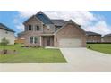 Two-story brick home with a large front yard and driveway at 115 Felicity Pike, Locust Grove, GA 30248