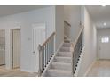 Modern staircase with black iron railing and carpeted steps at 328 Shine Dr, Stockbridge, GA 30281