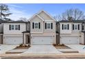 Two-story townhome with white and gray siding, two-car garage, and landscaping at 401 Brooch Way, Stockbridge, GA 30281