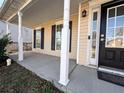 Covered front porch with white columns and a black front door at 1760 Marceau Dr, Conley, GA 30288