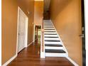 Grand staircase with dark wood treads and white risers at 1760 Marceau Dr, Conley, GA 30288