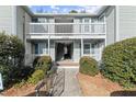 Two-story condo building featuring gray siding, white railings, and well-maintained landscaping at 2042 Brian Way, Decatur, GA 30033