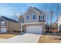 Two-story home with brick and gray siding, two-car garage, and a partially visible yard at 277 Tulip Dr, Covington, GA 30016