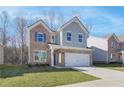 Two-story home with brick and gray siding, a two-car garage and front yard at 277 Tulip Dr, Covington, GA 30016