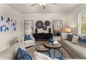 Open living room with sectional sofa, decorative wall art, and hardwood floors at 3098 Steinbeck Way, East Point, GA 30344