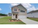 Two-story home with light brick and siding, two-car garage, and landscaping at 75 Barge Ln, Covington, GA 30016