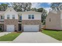 Two-story brick townhome with a two-car garage and landscaped front yard at 328 Navigator Ln, Mcdonough, GA 30253