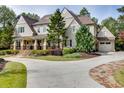 Home featuring a long driveway, well-manicured lawn, and mature landscaping at 923 Little Darby Ln, Suwanee, GA 30024