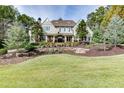 Beautiful home exterior with manicured lawn, mature trees, and elegant landscaping at 923 Little Darby Ln, Suwanee, GA 30024