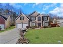 Brick two-story house with a two-car garage and landscaped lawn at 1943 Ivy Branch Ct, Loganville, GA 30052