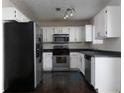 Galley-style kitchen with stainless steel appliances and white cabinets at 826 Shore Drive, Lithonia, GA 30058