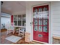 Inviting front porch with rocking chairs and a decorative red front door at 3529 Flowering Spgs, Powder Springs, GA 30127