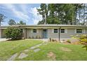 Newly renovated ranch home with a light gray brick exterior, and a landscaped lawn at 311 Mark Ave, Marietta, GA 30066