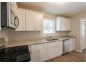 Renovated kitchen with white cabinets and granite counters at 29 Oak Sw Dr, Atlanta, GA 30354