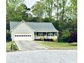 A charming, single-story home with an attached garage, covered porch, and landscaped front yard at 399 Towler Dr, Loganville, GA 30052