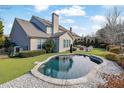 Relaxing kidney-shaped pool surrounded by landscaping at 104 Johnston Farm Ln, Woodstock, GA 30188