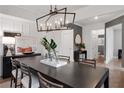 Dark wood dining table with chandelier and adjacent hallway view at 6075 Marigold Way, Atlanta, GA 30349