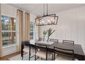 Elegant dining room with chandelier, large window, and wood table at 6075 Marigold Way, Atlanta, GA 30349