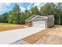 Long driveway leading to a gray siding home with a spacious two-car garage at 121 Hunters Ln, Powder Springs, GA 30127