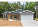 Charming new construction home with gray siding, wood accents, and a pristine two-car garage at 121 Hunters Ln, Powder Springs, GA 30127