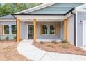 Inviting front porch with wood columns and accents complementing the home's gray siding at 121 Hunters Ln, Powder Springs, GA 30127