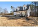 Two-story farmhouse with a white exterior, gray roof and a large front porch at 56 Veranda Walk, Dallas, GA 30157