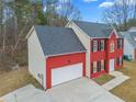 Two-story house with a red brick and beige vinyl exterior, gray roof, and a two-car garage at 1029 Chaterly Ct, Riverdale, GA 30296