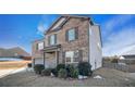 Two-story brick home with gray garage door, landscaping, and partial snow at 8484 Glenview St, Douglasville, GA 30134