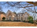 Two-story house with stone and brick facade, situated on a sloping lot with mature trees at 2760 Veltre Sw Ter, Atlanta, GA 30311