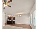 Spacious living room with hardwood floors, ceiling fan, and kitchen view at 757 Galveston Way, Mcdonough, GA 30253