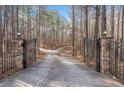 Private gated driveway leading to a secluded home surrounded by lush greenery and mature trees at 10 Moss Landing Se Rd, Acworth, GA 30102