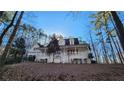 Gorgeous two-story home with an inviting wraparound porch framed by mature trees on a sunny day at 10 Moss Landing Se Rd, Acworth, GA 30102