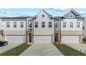 New townhome with a bright white facade and a private two-car garage at 8214 Tiger Way, Riverdale, GA 30274