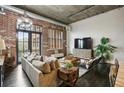 Spacious living room with exposed brick, hardwood floors, and comfortable seating at 3235 Roswell Ne Rd # 718, Atlanta, GA 30305