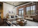 Open living area with exposed brick wall, large windows and comfortable seating at 3235 Roswell Ne Rd # 718, Atlanta, GA 30305