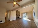 Living room with hardwood floors, stone fireplace, and access to other rooms at 8263 Canyon Forge Dr, Riverdale, GA 30274