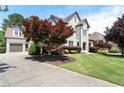 Charming white brick home featuring manicured landscaping, driveway, and an attached two car garage at 183 Applewood Ln, Acworth, GA 30101