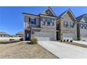 New townhome showing brick facade, a two car garage, and manicured front yard at 3353 Pearl Ridge Way, Buford, GA 30519