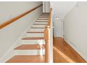 Elegant wooden staircase with a light-colored railing and hardwood floors at 140 Sandy Dr, Stockbridge, GA 30281