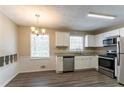 Bright kitchen with white cabinets, granite counters, and stainless steel appliances at 530 Balfour Dr, Decatur, GA 30032