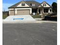 Beige two-story house with a three-car garage and landscaping at 1609 Tielman Way, Snellville, GA 30078