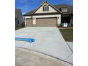 Beige house with a three-car garage and large concrete driveway at 1609 Tielman Way, Snellville, GA 30078