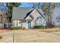 Tan house with gray roof, landscaping, and a small driveway at 145 Turning Pt, Stockbridge, GA 30281