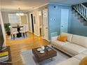 Virtually staged living room with off-white couch and a dining area at 1683 Briarcliff Ne Rd # 4, Atlanta, GA 30306