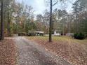 House with driveway and detached buildings, surrounded by trees at 3780 Hutcheson Ferry Rd, Whitesburg, GA 30185