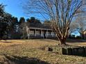 House with a large tree in front and a sloped yard at 3709 Charlotte Dr, Rex, GA 30273